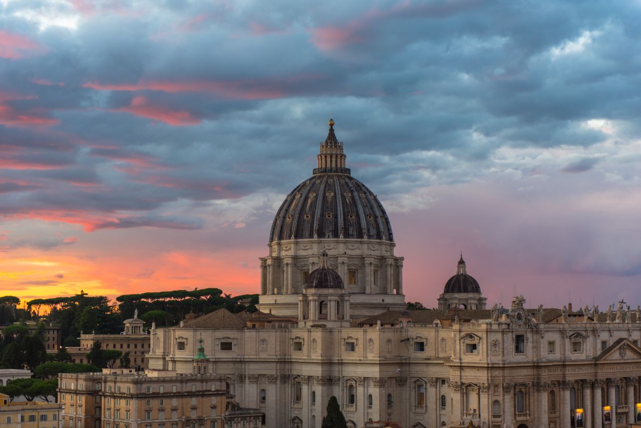 Beautiful view of St. Peter's Basilica surrounded by a vibrant sunset sky.